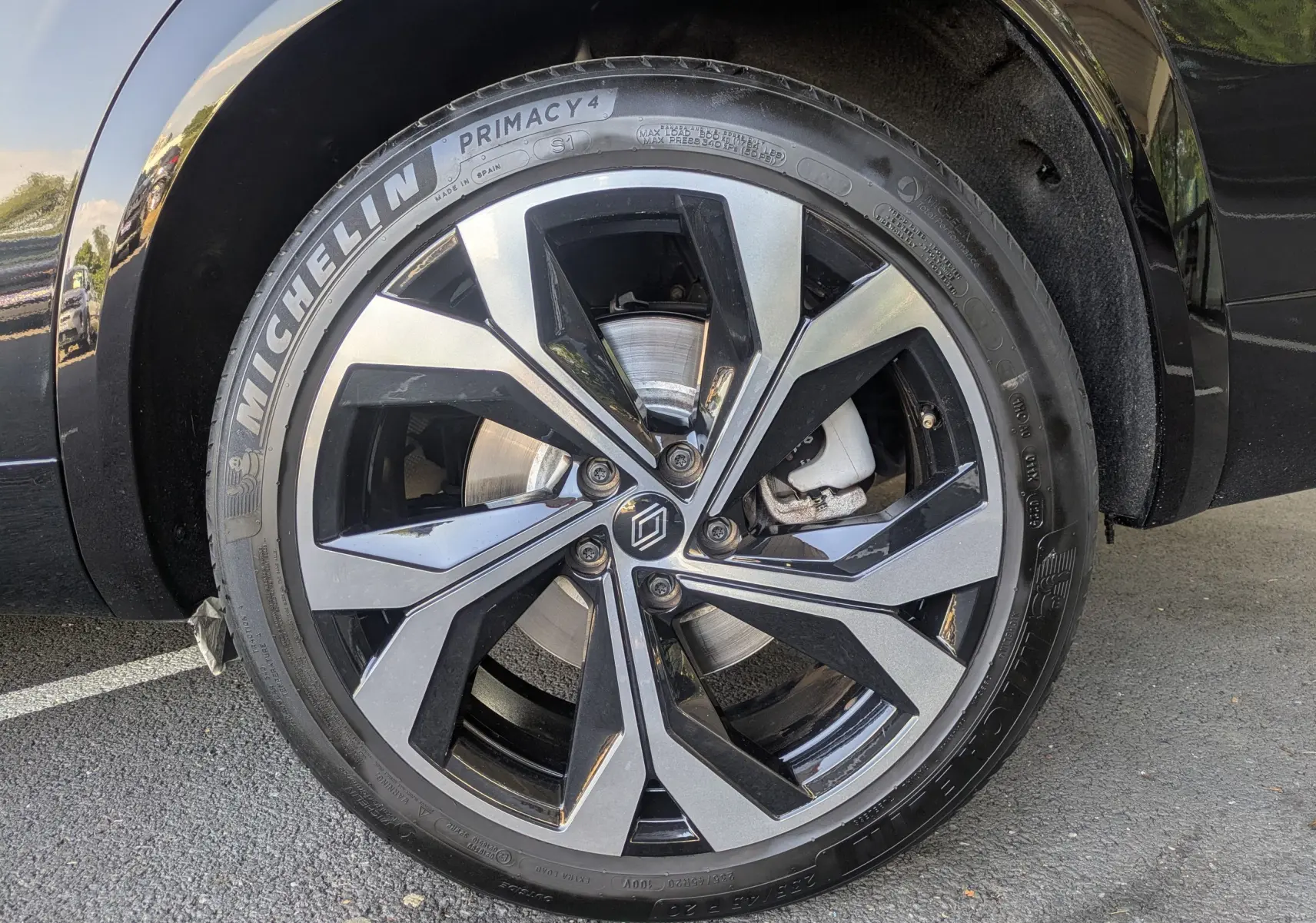 Gros plan sur la jante alliage 20 pouces Daytona noire et grise du Renault Espace VI noir Étoile, roue avant droite.