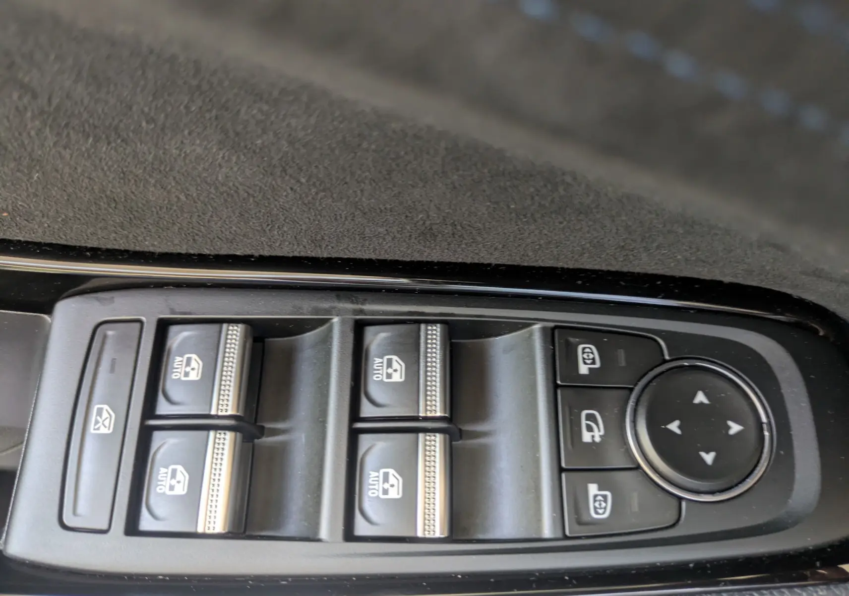 Gros plan sur les commandes de lève-vitres et réglages des rétroviseurs du Renault Espace VI noir étoile.