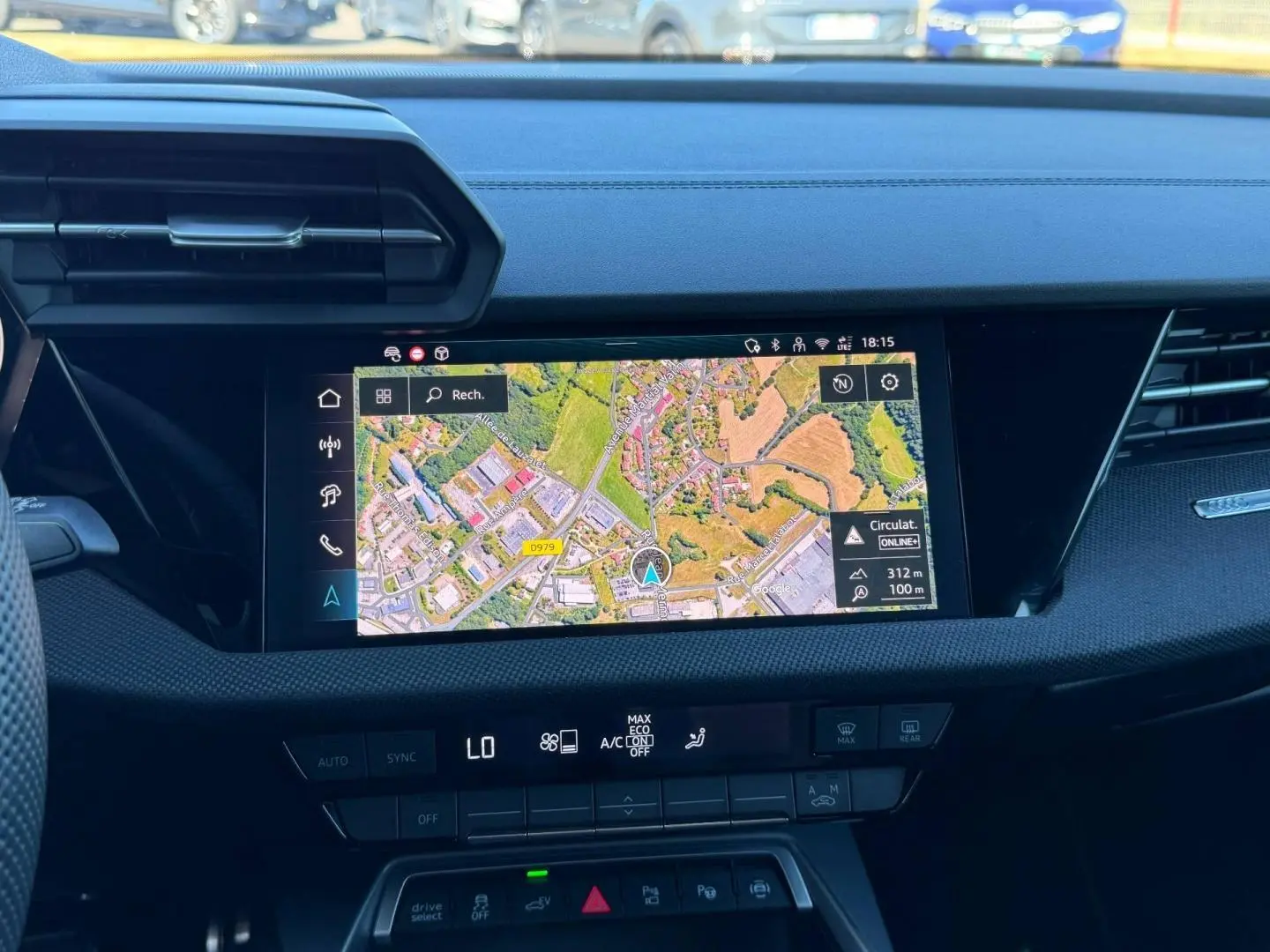 Vue intérieure du tableau de bord de l'Audi A3 Sportback 2025 avec écran GPS couleur et commandes de climatisation.