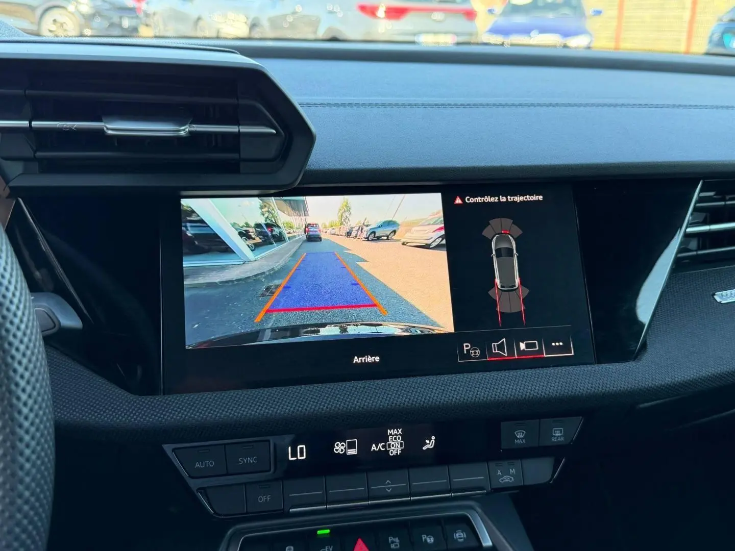 Vue intérieure du tableau de bord de l'Audi A3 Sportback 2025 avec écran de caméra de recul affichant l'arrière en noir Mythic métallisé.