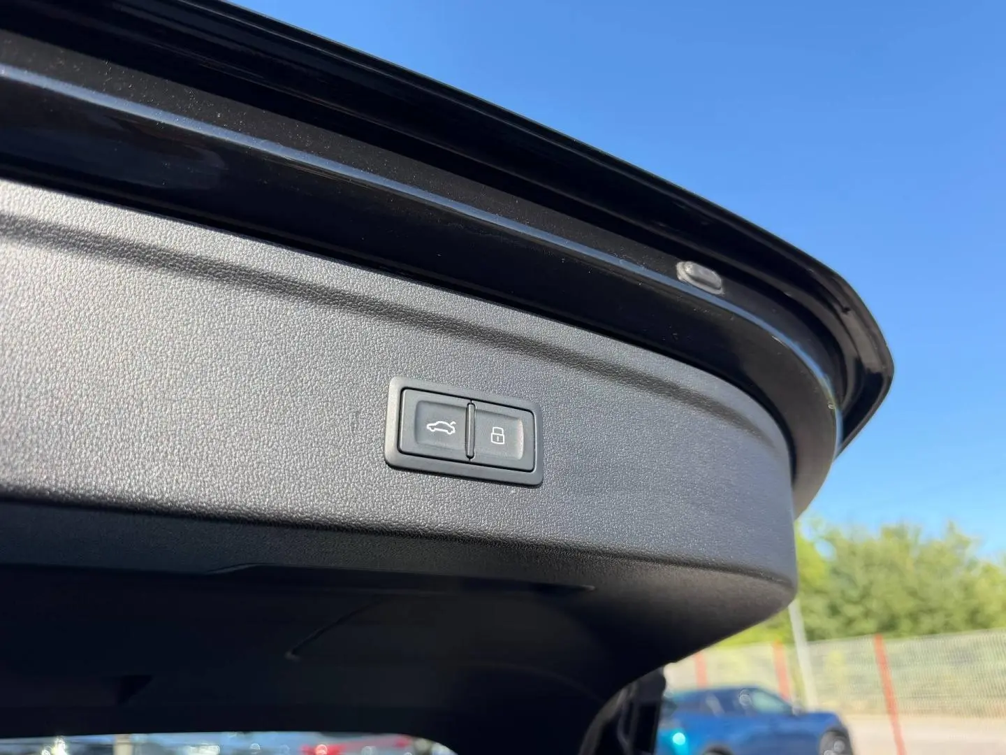 Bouton d'ouverture et de verrouillage du coffre sur la trappe arrière d'une Audi A3 Sportback noir Mythic métallisé.