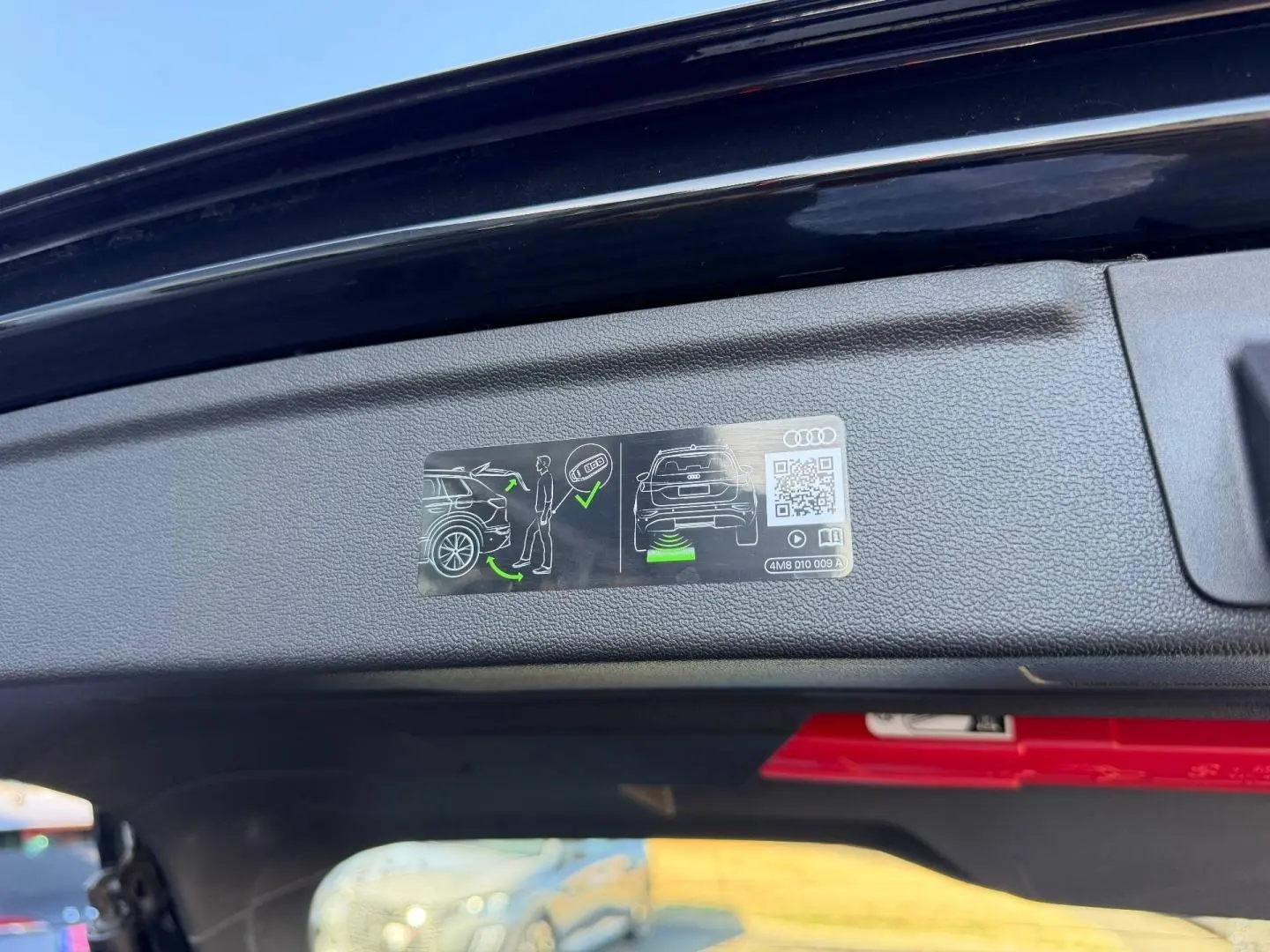 Vue rapprochée de l’intérieur du coffre ouvert d’une Audi A3 Sportback noir Mythic métallisé, avec consigne d’utilisation affichée.