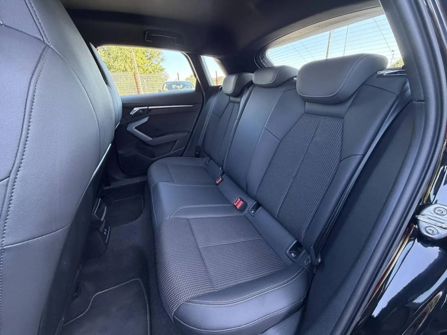 Vue latérale droite sur la banquette arrière noire en tissu et simili de l’Audi A3 Sportback 2025 finition S line.