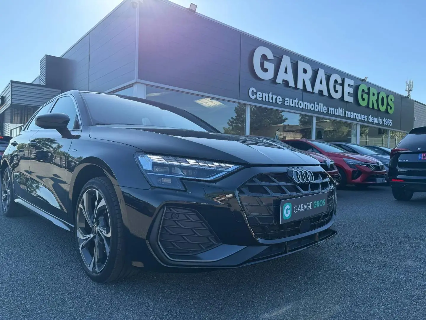 Audi A3 Sportback noir Mythic métallisé vue 3/4 avant gauche, avec jantes alu et calandre S line visible.