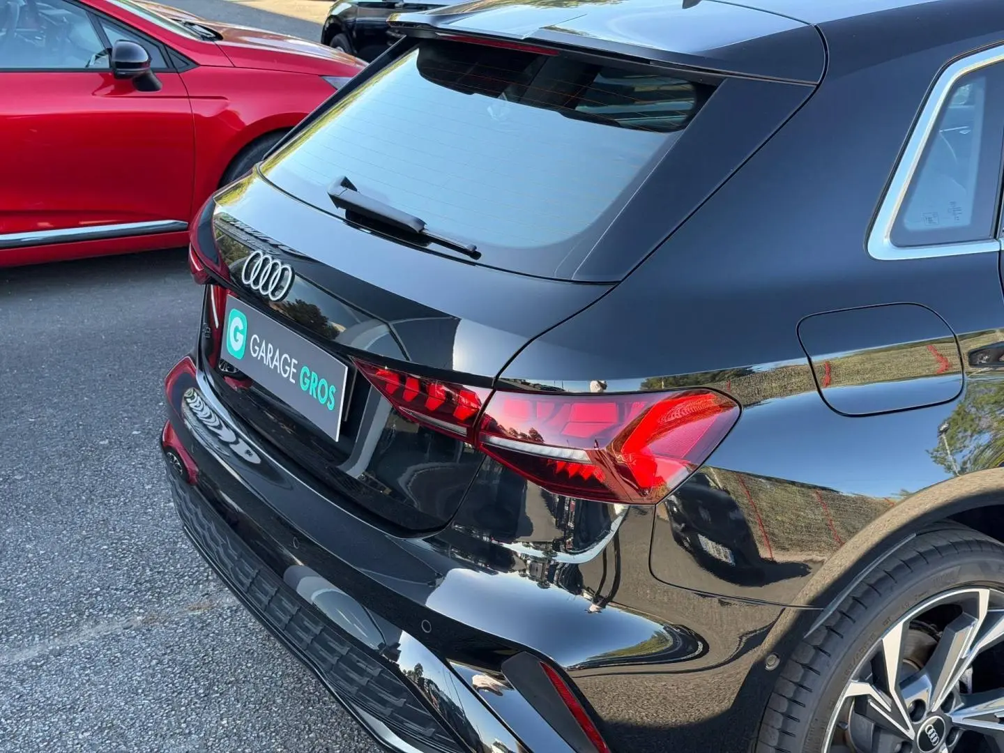 Vue 3/4 arrière droite d'une Audi A3 Sportback 2025 noir Mythic métallisé avec feux arrière LED et jantes alu.