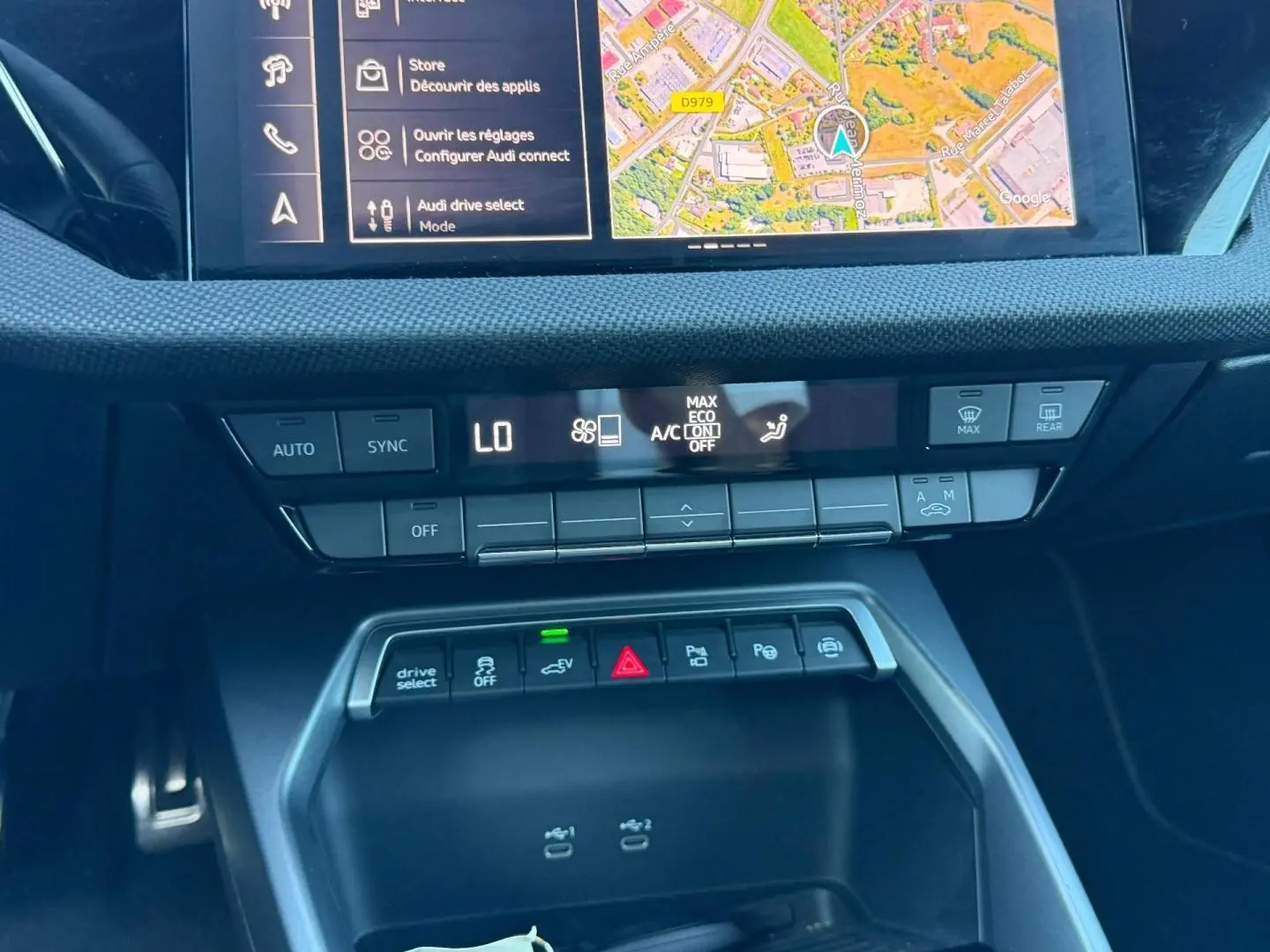 Vue rapprochée de la console centrale de l'Audi A3 Sportback 2025 avec commandes climatisation et écran GPS.