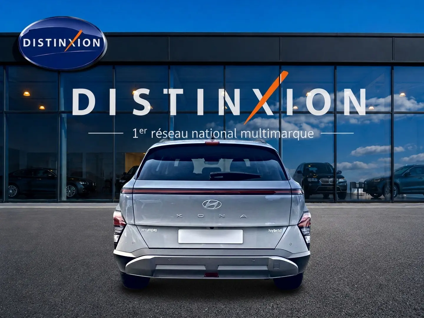 Vue arrière d'un Hyundai Kona gris hybride 2025, avec feux arrière LED et bande lumineuse distinctive.