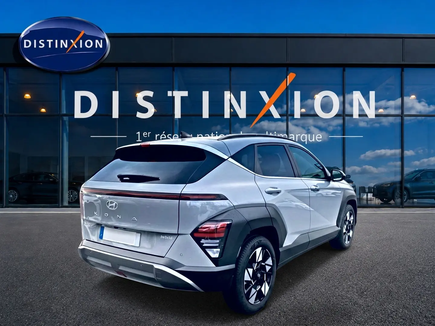 Vue 3/4 arrière droite du Hyundai Kona gris 2025 avec feux LED et jantes alliage 18 pouces devant un showroom Distinxion.