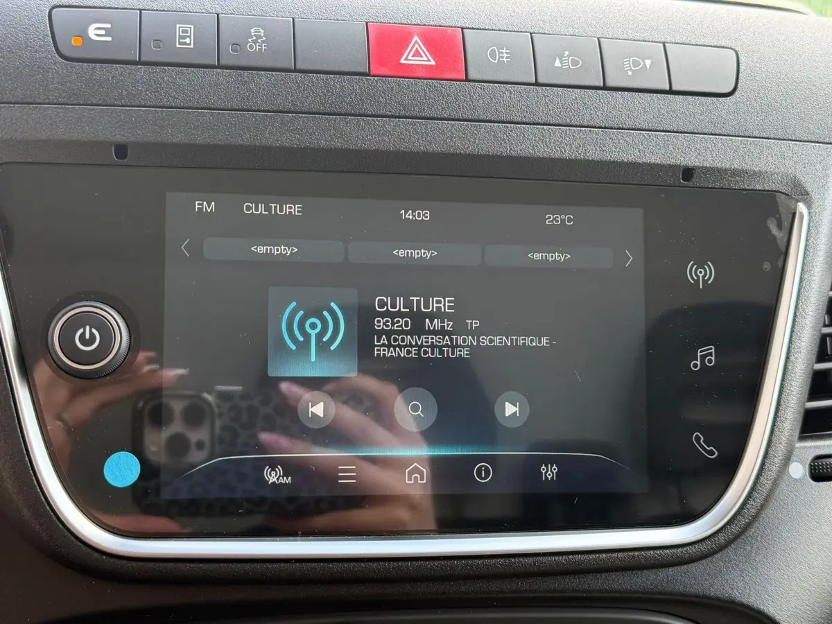 Gros plan sur l’écran tactile central du tableau de bord de l’Iveco Daily blanc, avec commandes et affichage radio FM.