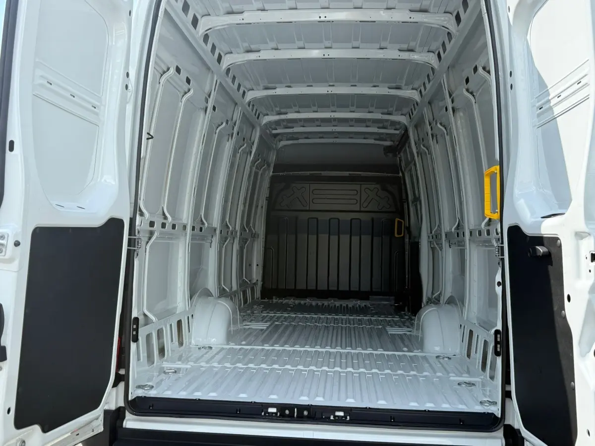 Vue intérieure arrière du fourgon blanc Iveco Daily 35S18 2026, montrant l'espace de chargement vide et les parois métalliques.
