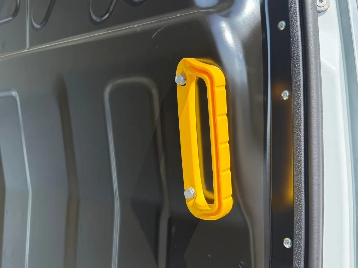 Poignée de maintien jaune en gros plan à l'intérieur d'un fourgon blanc Iveco Daily 35S18 2026.