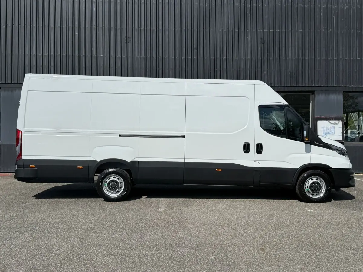 Fourgon Iveco Daily blanc vu de profil côté droit, avec bas de caisse noir et jantes acier simples.