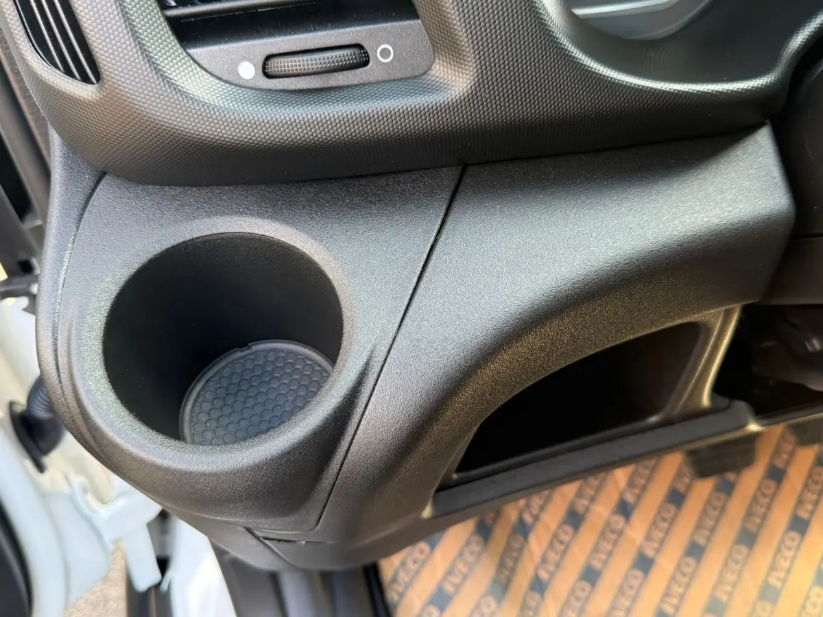 Gros plan sur le rangement et porte-gobelet côté droit de l’habitacle du fourgon blanc Iveco Daily 35S18 2026.