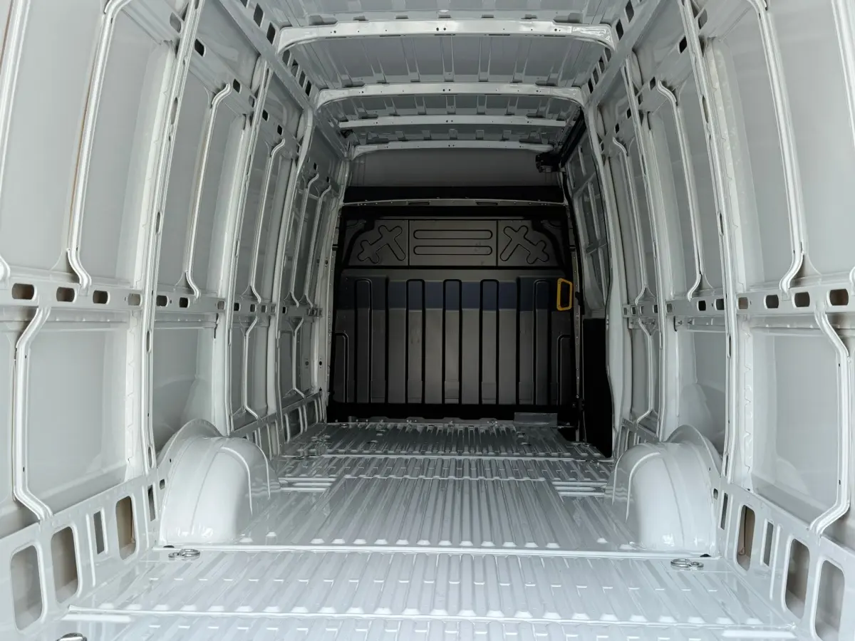 Vue intérieure de la cabine arrière blanche d’un Iveco Daily 35S18 3.0 V16 Himatic BVA H2, montrant l’espace de chargement vide.