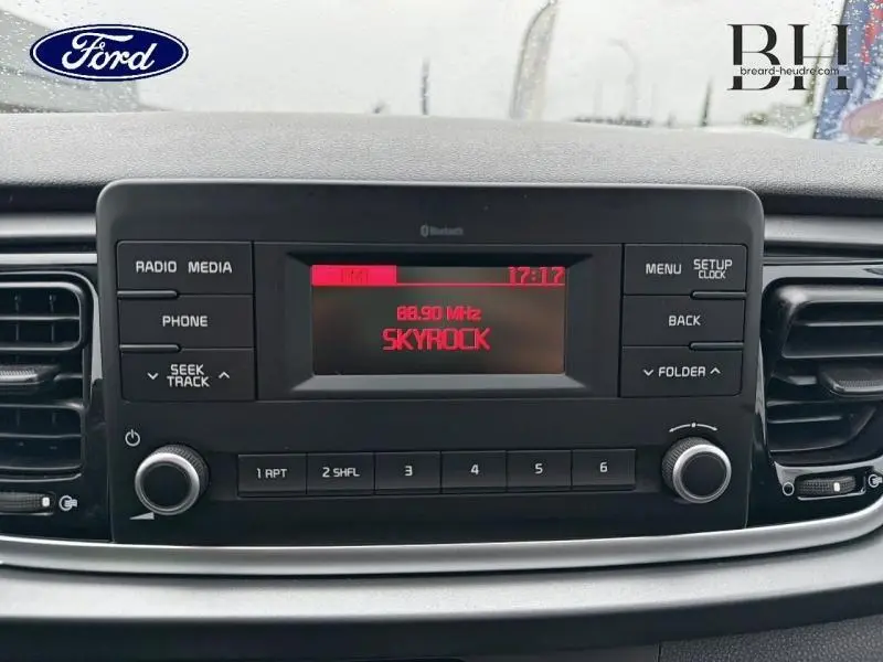 Affichage central de la radio d'une KIA RIO noire, vue de face sur l'écran numérique avec station Skyrock.