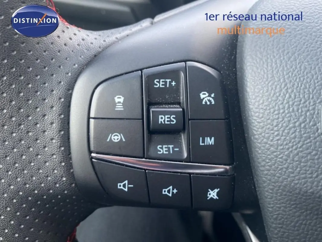 Gros plan sur les commandes au volant à gauche de la Ford Focus gris foncé 2024, avec régulateur de vitesse et assistant maintien.