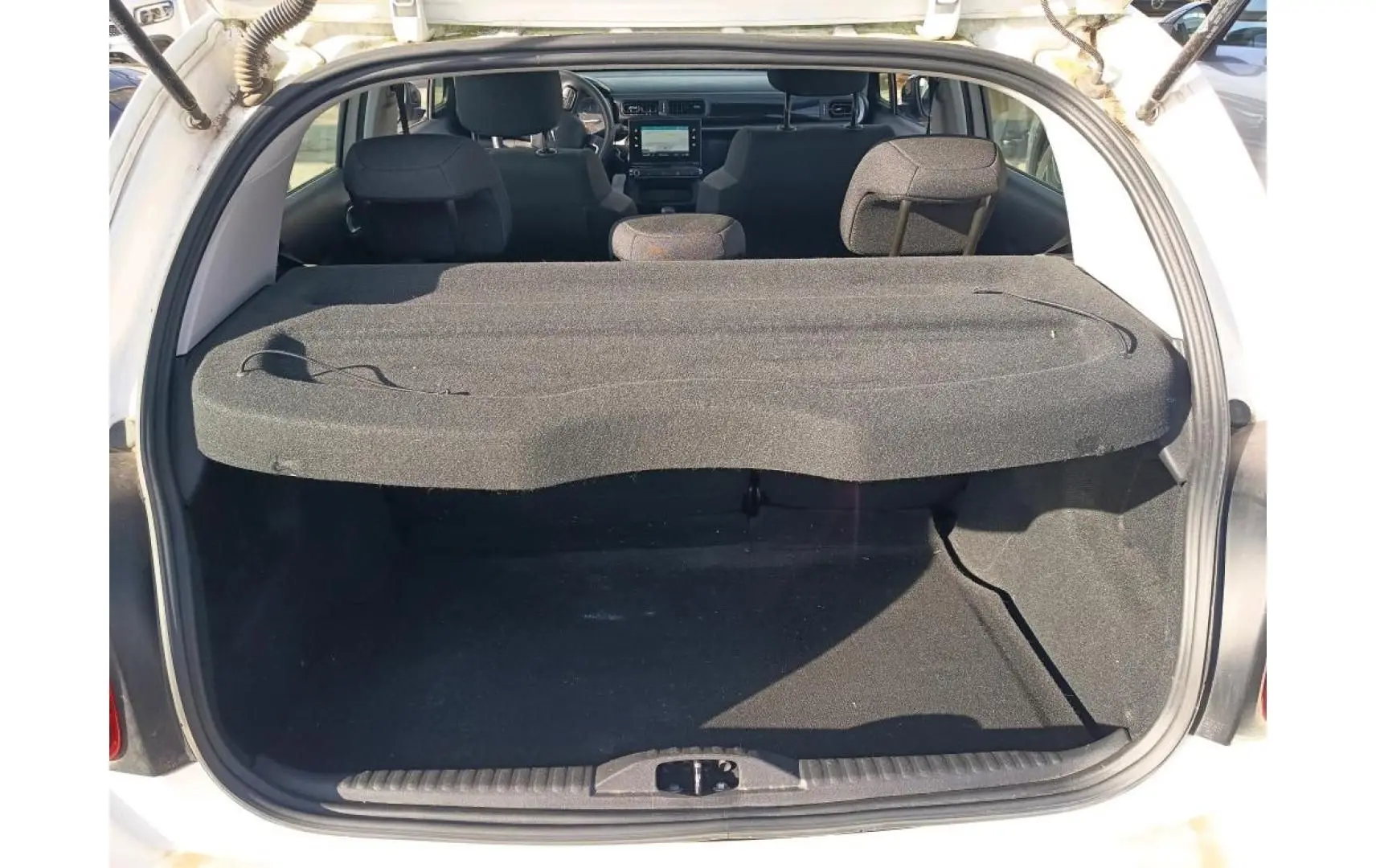 Coffre ouvert d’une Citroën C3 blanche 2021, vue arrière montrant l’espace de chargement et l’intérieur noir.
