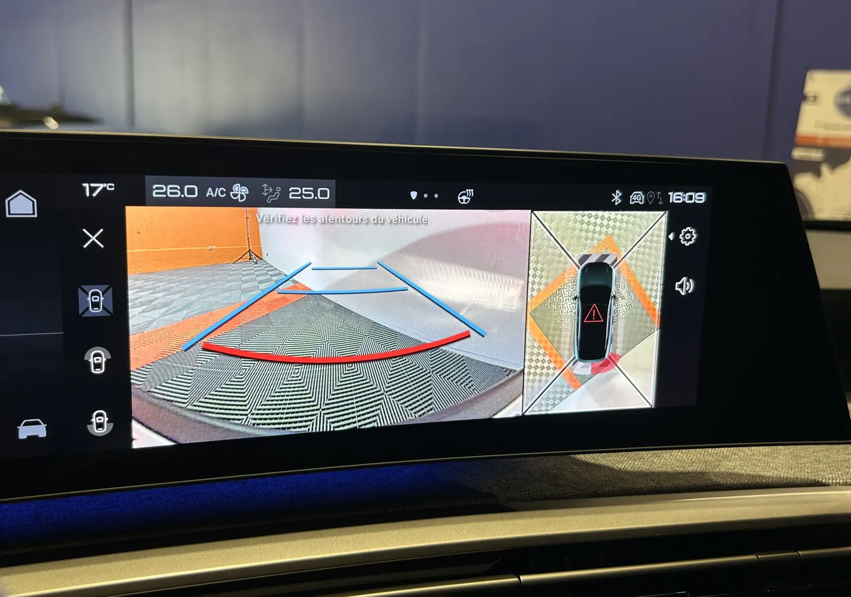 Écran tactile du Peugeot 3008 hybride 2024 montrant la caméra 360° avec vue arrière et plan en survol, intérieur noir.