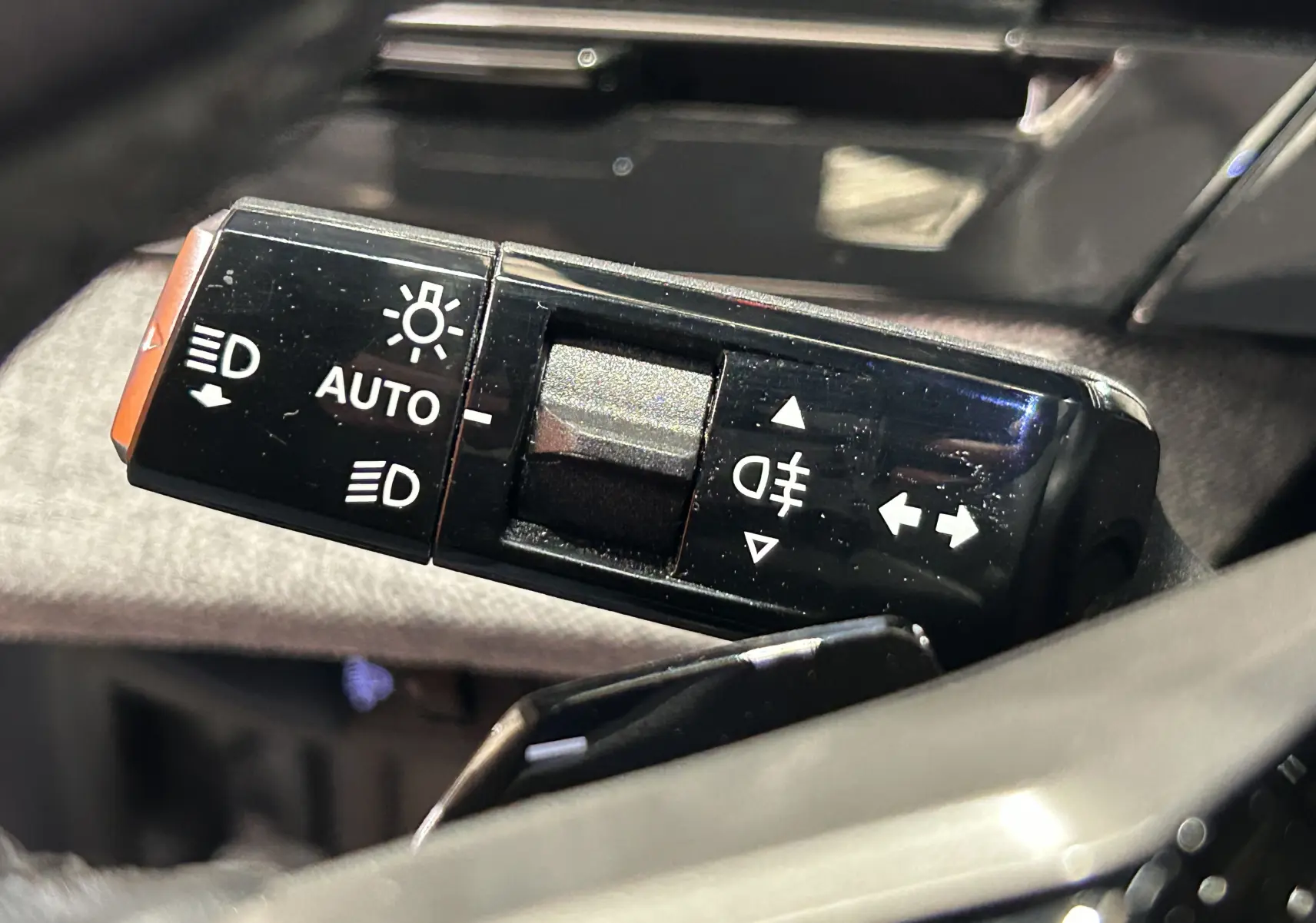 Gros plan sur la commande des feux et clignotants du Peugeot 3008 gris Artense, intérieur côté gauche.