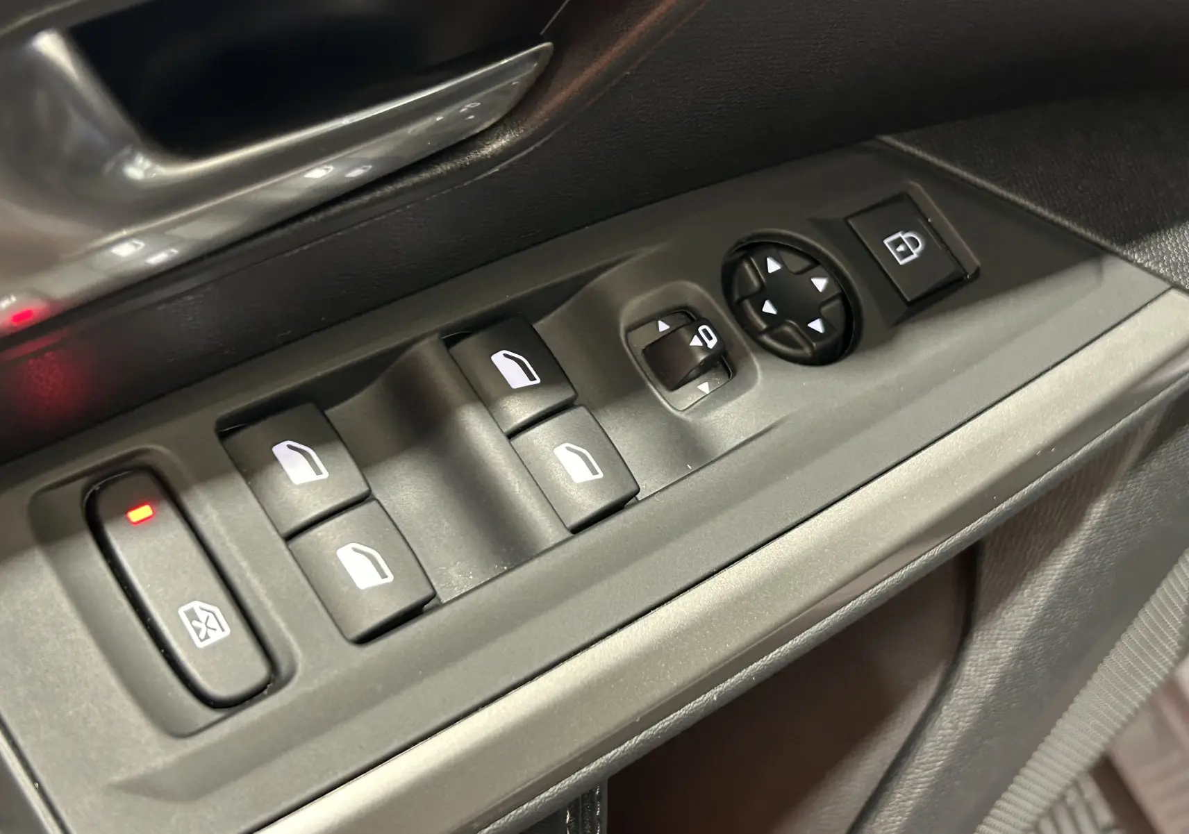 Gros plan sur les commandes de lève-vitres et réglage des rétroviseurs côté conducteur du Peugeot 3008 gris Artense.