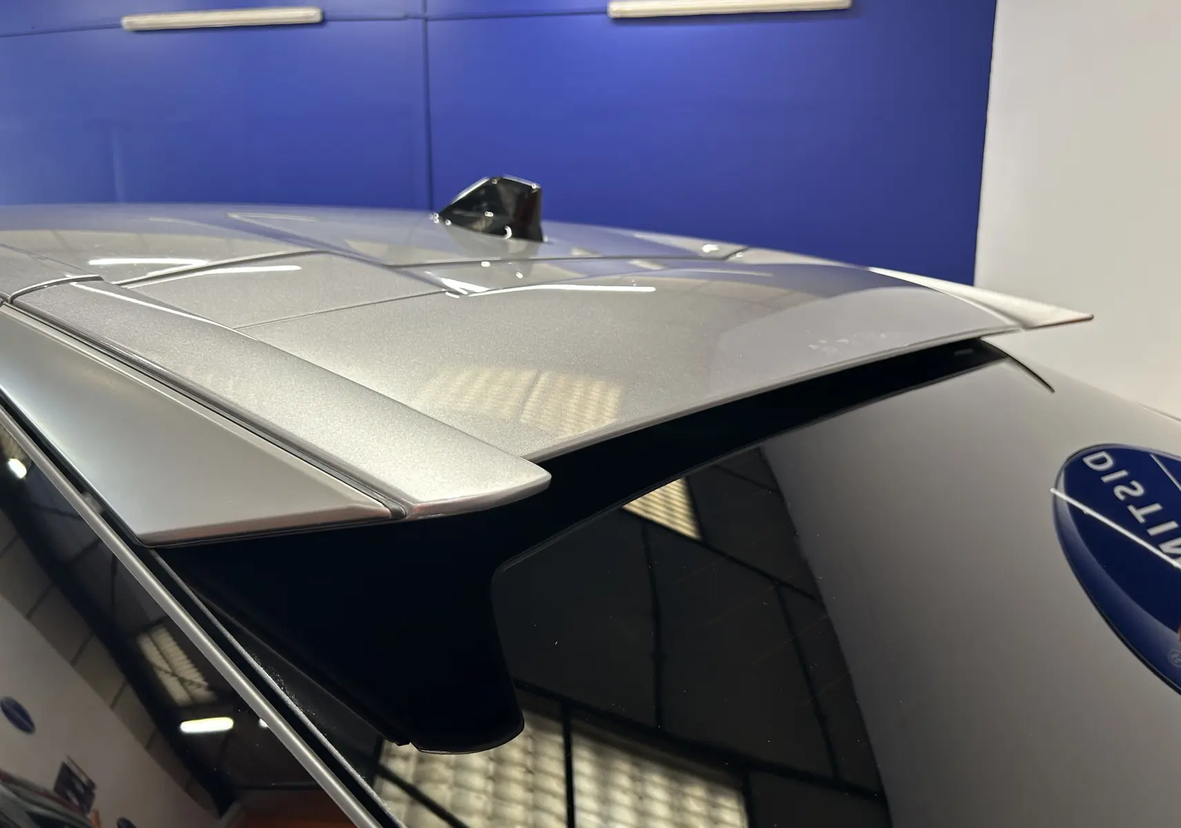 Détail du toit gris Artense du Peugeot 3008 III Hybrid avec antenne requin et becquet arrière, vue en plongée.