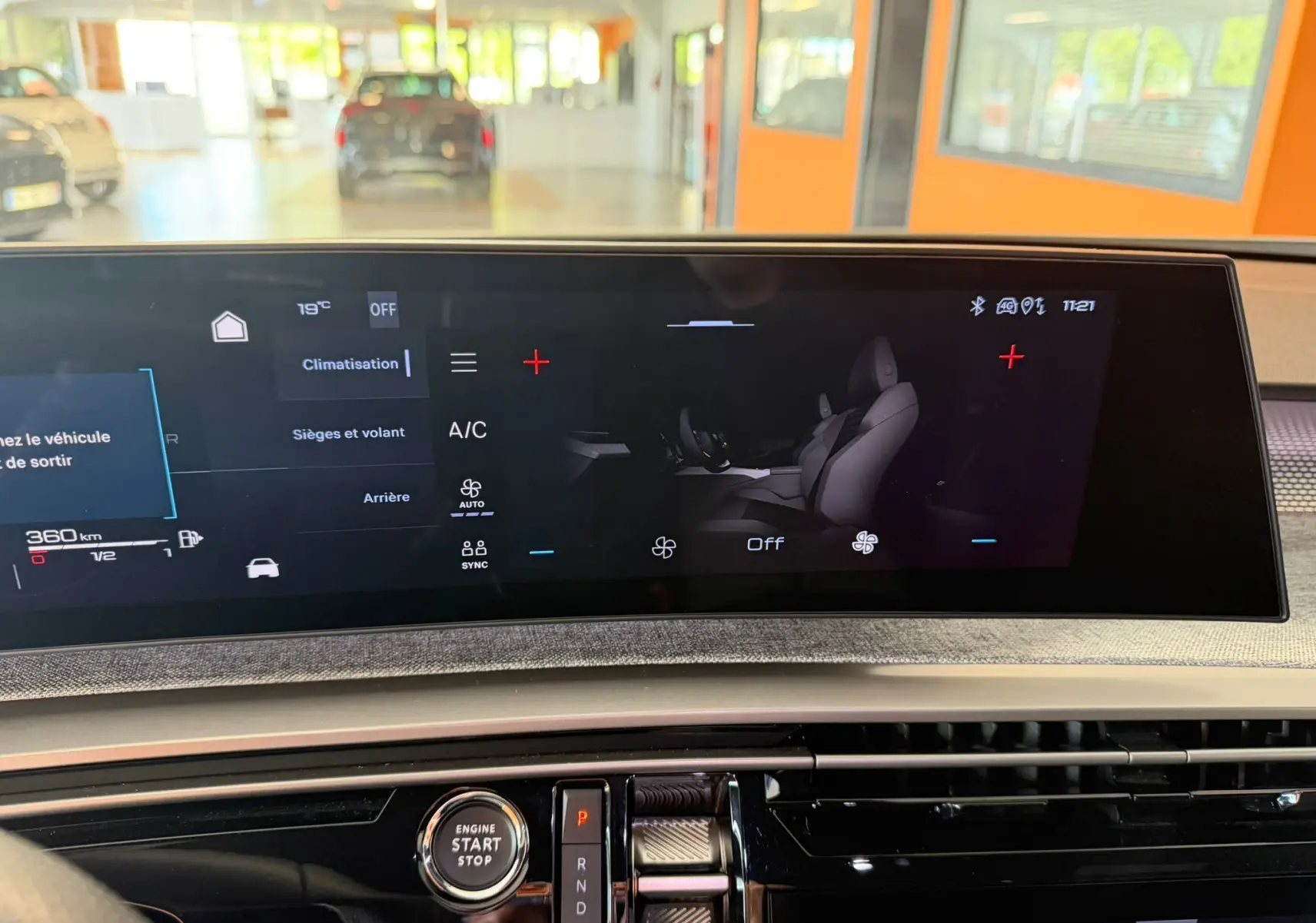 Écran tactile HD 21’’ du Peugeot 5008 Hybrid 145 GT montrant les réglages de climatisation et sièges, intérieur moderne.