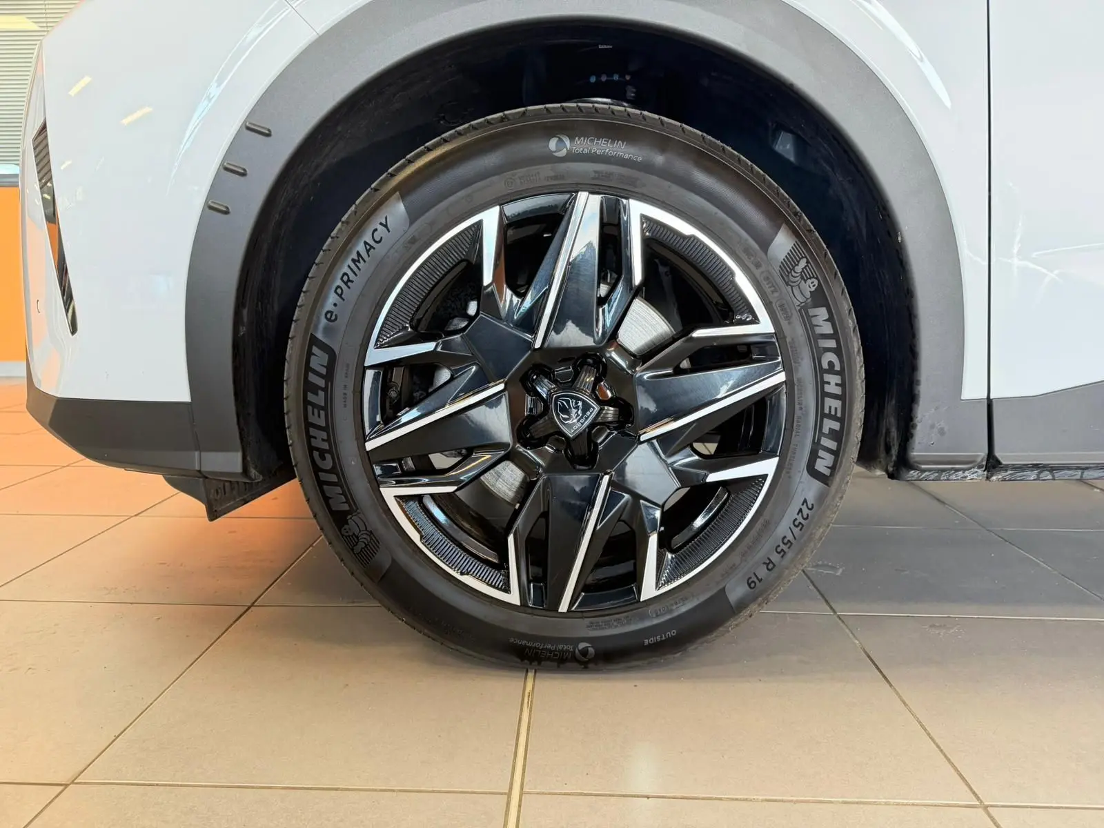 Gros plan sur la jante alliage 19’’ noire et chromée du Peugeot 5008 Hybrid 145 blanc Okenite, côté arrière droit.