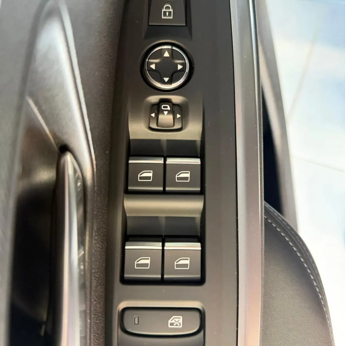 Vue rapprochée des commandes de lève-vitres et rétroviseurs côté conducteur du Peugeot 5008 Hybrid 145 e-DCS6 GT.