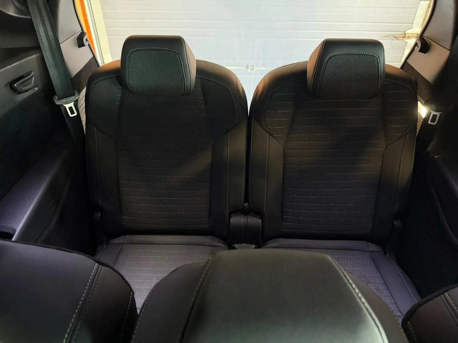 Vue arrière intérieure montrant les deux sièges arrière noirs du Peugeot 5008 Hybrid 145 e-DCS6 GT 2025.
