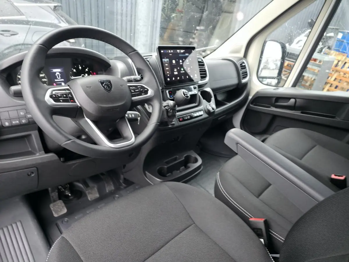 Vue intérieure côté conducteur du Peugeot Boxer Fourgon 2025, montrant le volant cuir et l’écran tactile central.