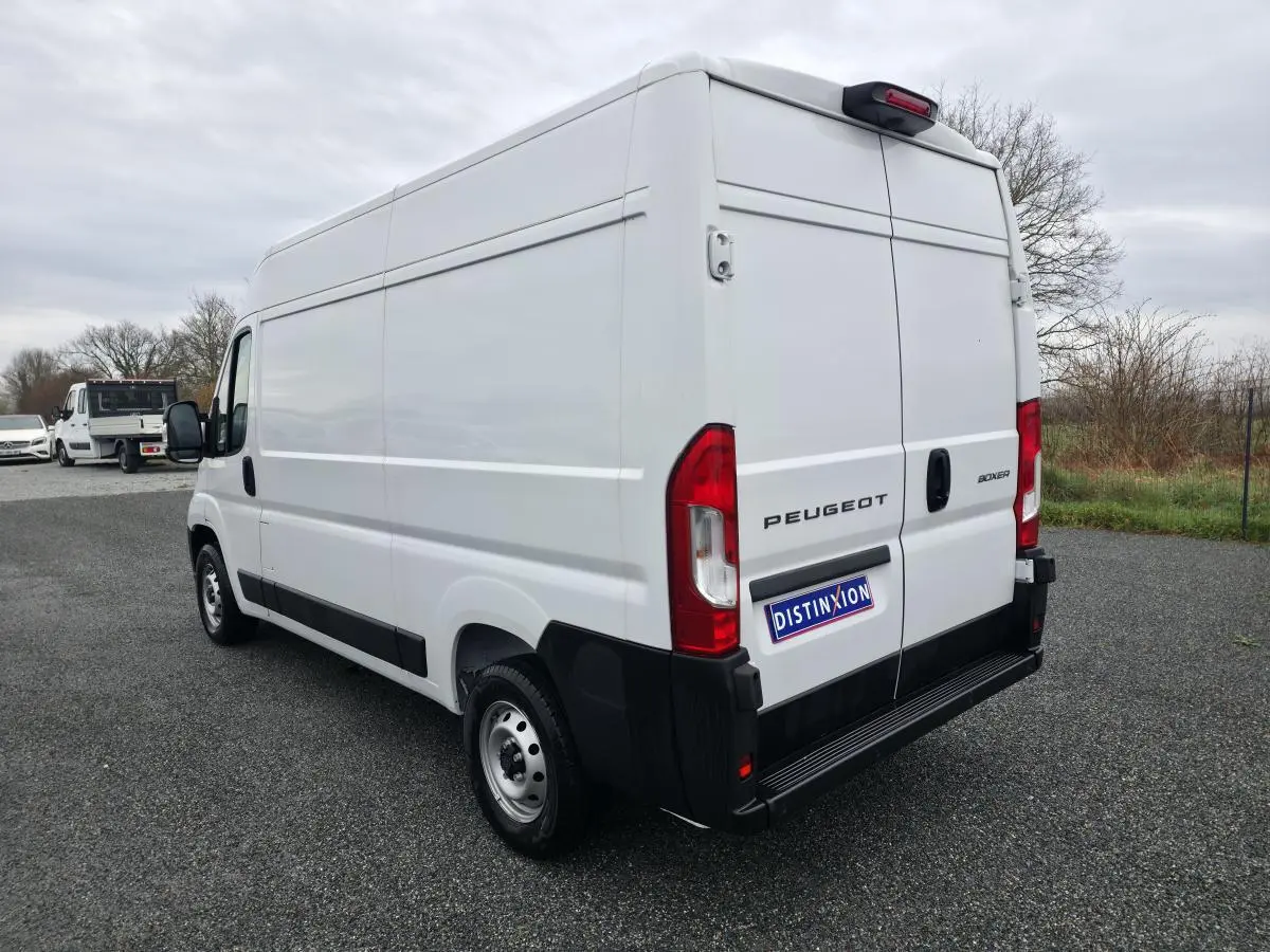 Vue 3/4 arrière droite du Peugeot Boxer Fourgon blanc, avec portes arrière fermées et jantes acier visibles.