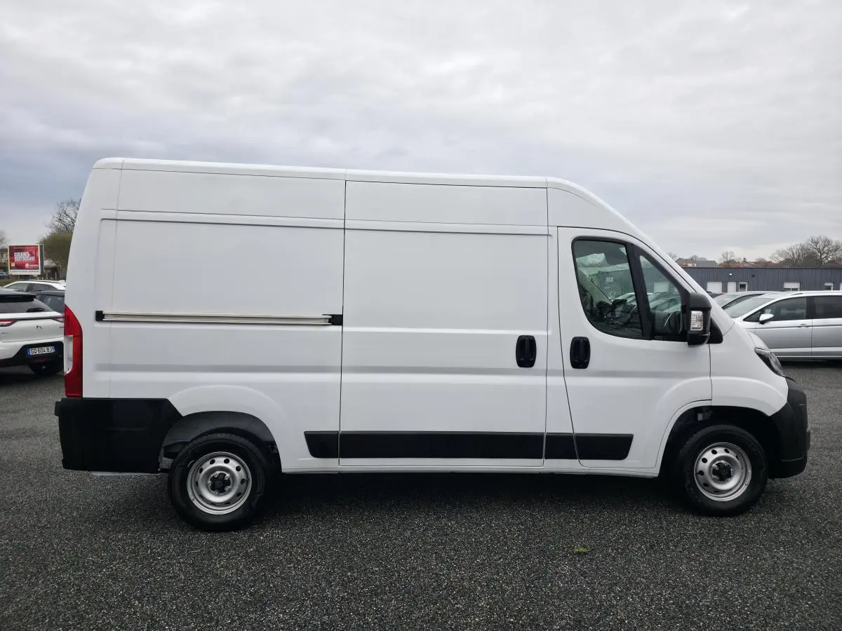 Vue latérale droite d’un Peugeot Boxer Fourgon blanc avec porte coulissante et roues acier 15 pouces.