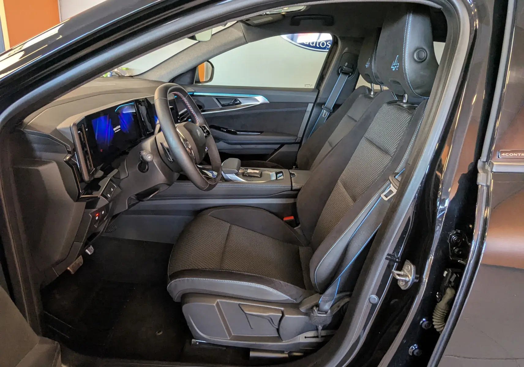 Vue intérieure côté conducteur du Renault Espace VI noir étoile, sièges mixte tissu/Alcantara avec logo Alpine brodé.