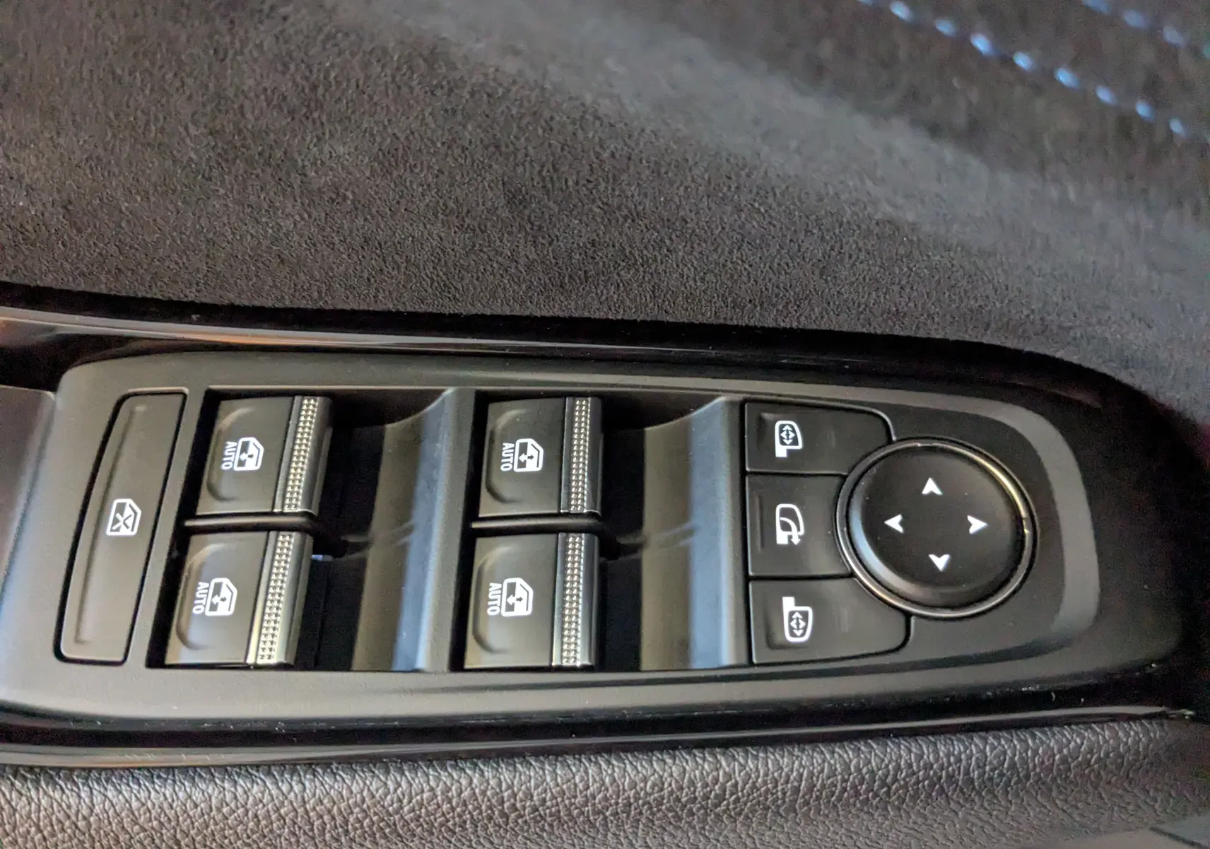 Gros plan sur les commandes des vitres électriques et rétroviseurs du côté gauche intérieur du Renault Espace VI noir étoile.
