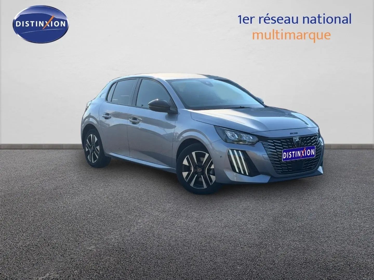 Peugeot 208 gris Artense vue 3/4 avant droit, avec calandre distinctive et jantes alliage noires et argentées.