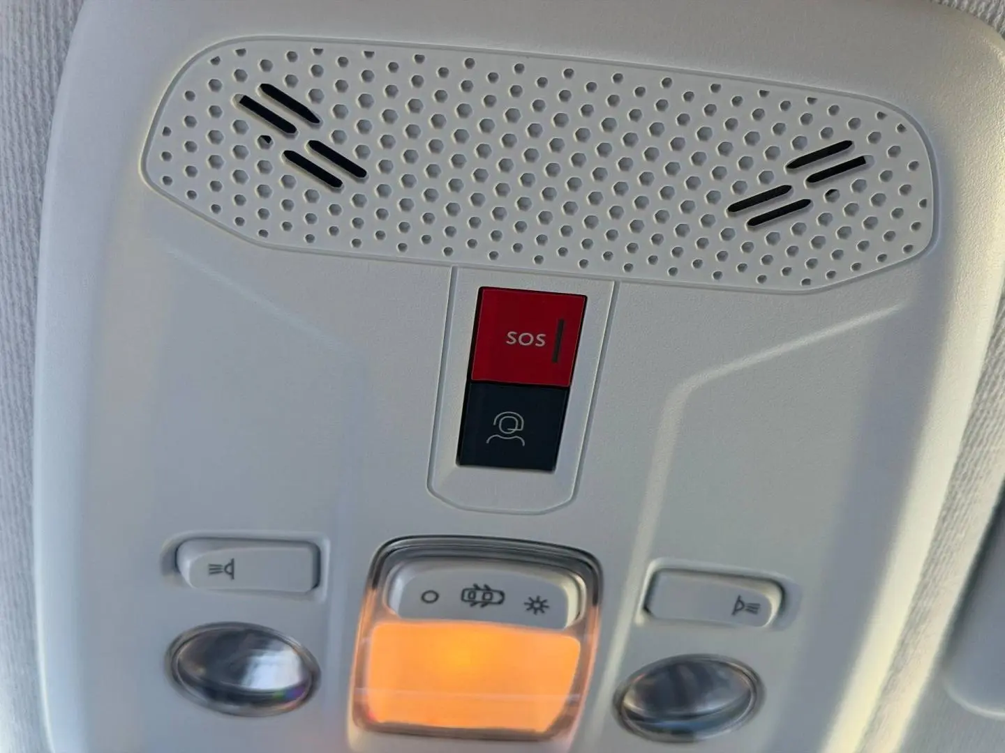 Détail du plafonnier intérieur gris clair avec bouton SOS rouge et éclairage ambre allumé sur Peugeot 208 1.2 100ch Allure.