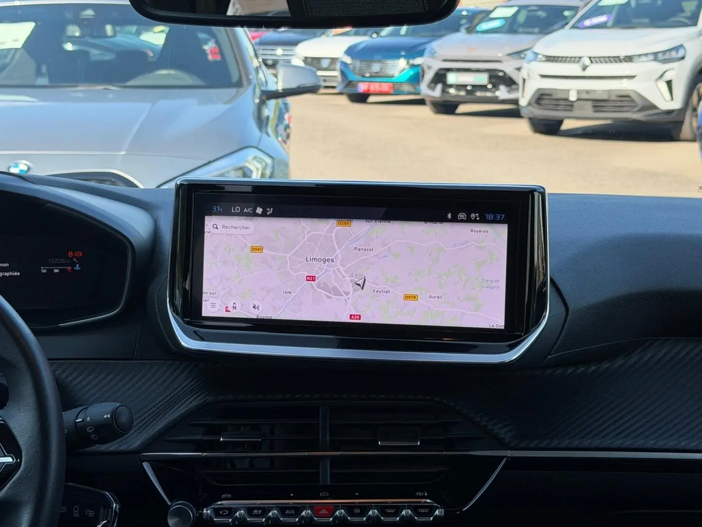 Vue intérieure centrée sur l'écran tactile du tableau de bord de la Peugeot 208 gris Artense, avec navigation affichée.