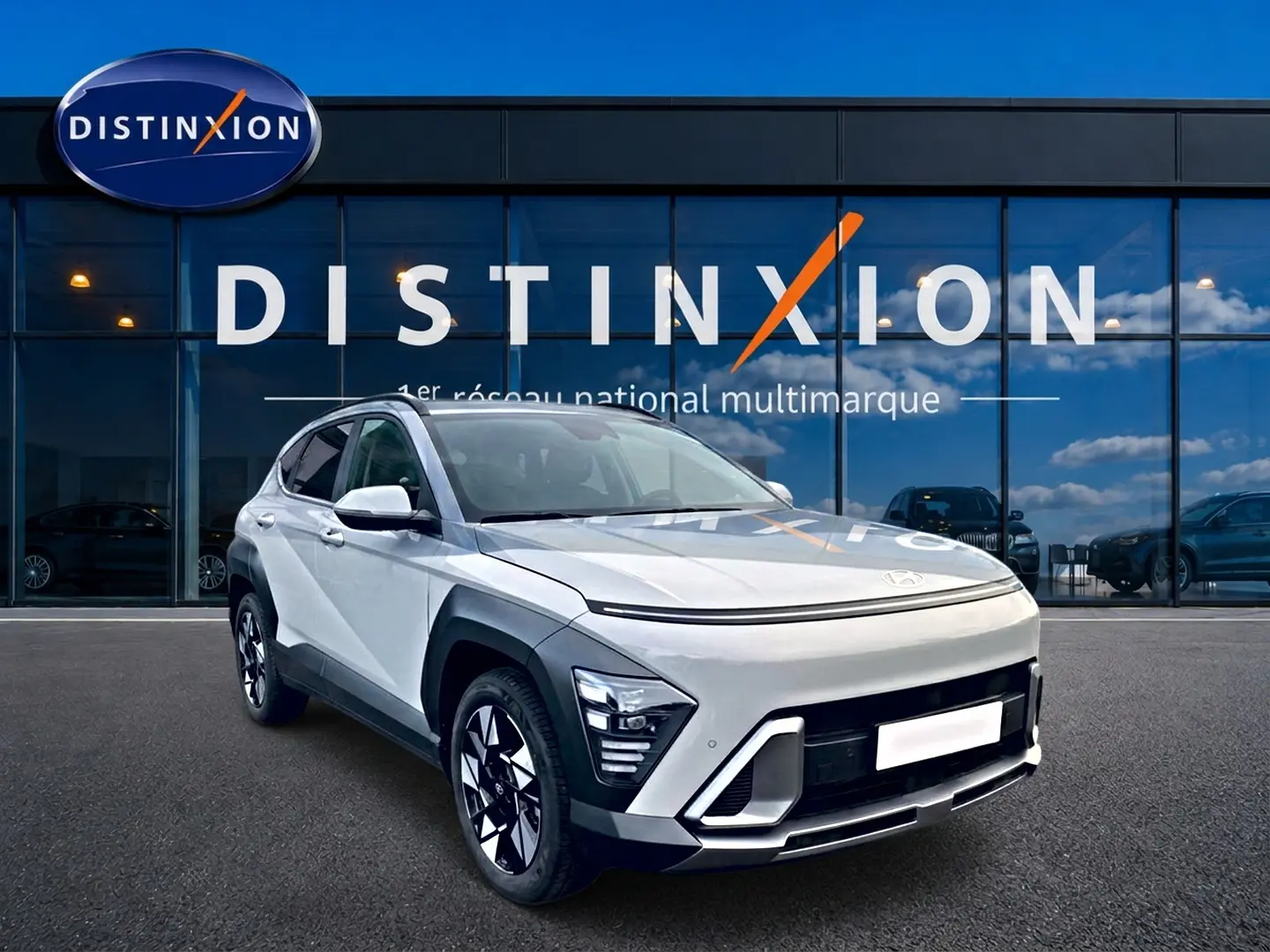 Hyundai Kona 2025 gris en 3/4 avant droit avec feux LED et jantes alliage devant showroom Distinxion.
