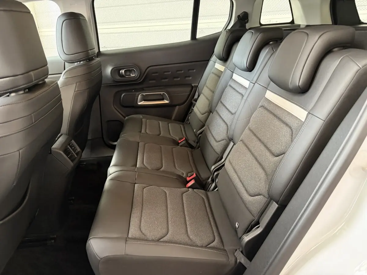 Vue latérale droite de l’intérieur arrière du Citroën C5 Aircross blanc, sièges 3 places en cuir et tissu gris.