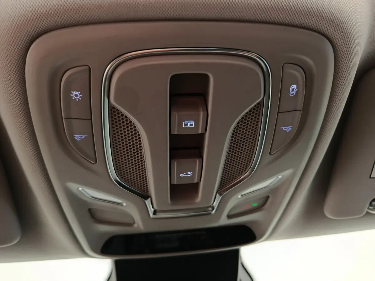 Vue en plongée sur le panneau de commandes de toit intérieur beige du MG Motor ZS Luxury 2024 avec éclairages et ouverture toit.