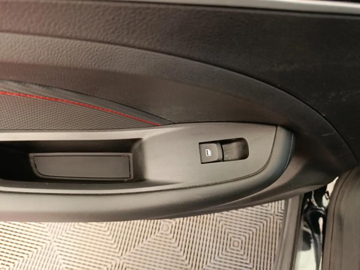 Détail de la commande de verrouillage sur la porte intérieure côté conducteur d’un MG ZS Luxury noir 2024.