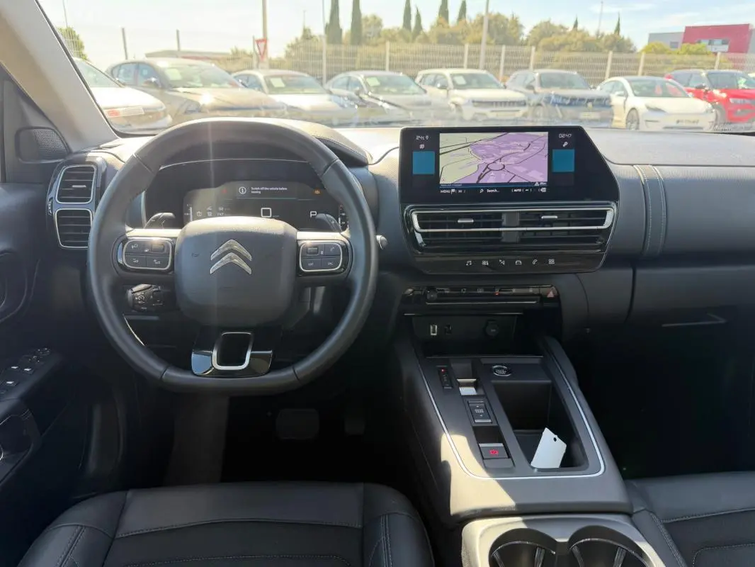 Vue intérieure centrée sur le volant et la console centrale du Citroën C5 Aircross hybride noir 2024 avec écran tactile et commandes intégrées.