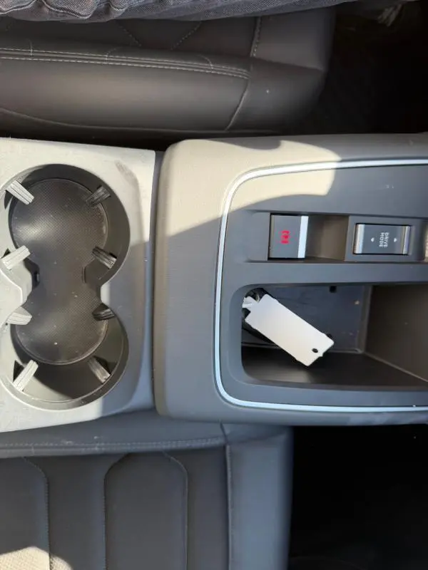 Vue rapprochée de la console centrale du Citroën C5 Aircross noir 2024, avec porte-gobelets et commandes électroniques.