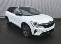Renault Austral E-Tech Full Hybrid 200 Iconic blanc nacré avec toit noir, vue 3/4 avant mettant en valeur ses phares LED et jantes alliage.