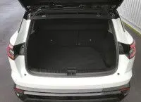 Vue arrière ouverte du coffre d'un Renault Austral 2025 blanc nacré avec toit noir, montrant l'espace de chargement vide.