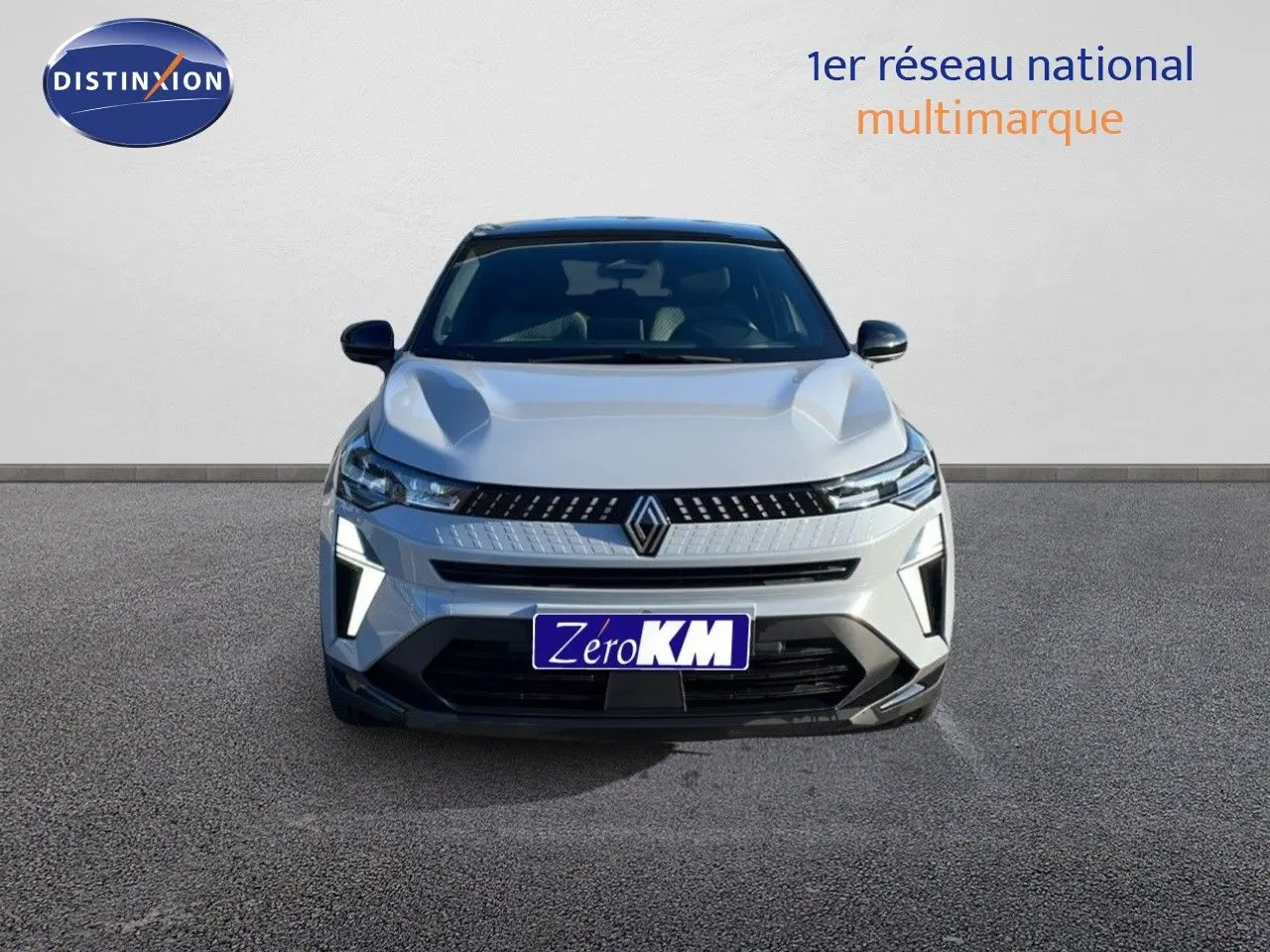 Vue avant d'un Renault Captur E-Tech hybride gris rafale métal avec toit noir et feux LED distinctifs allumés.