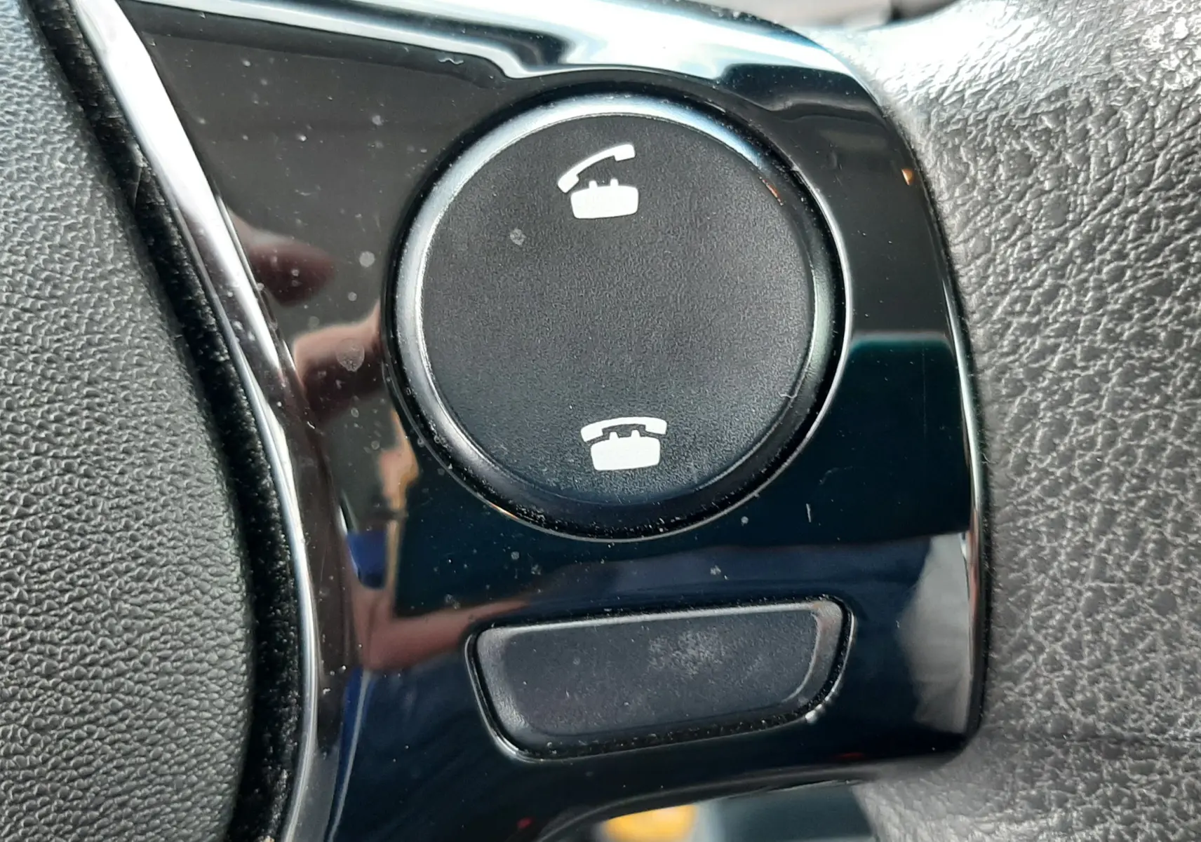 Bouton de commande d'appel téléphonique sur le volant noir du Citroën C1 blanc, version 2021, finition Feel.