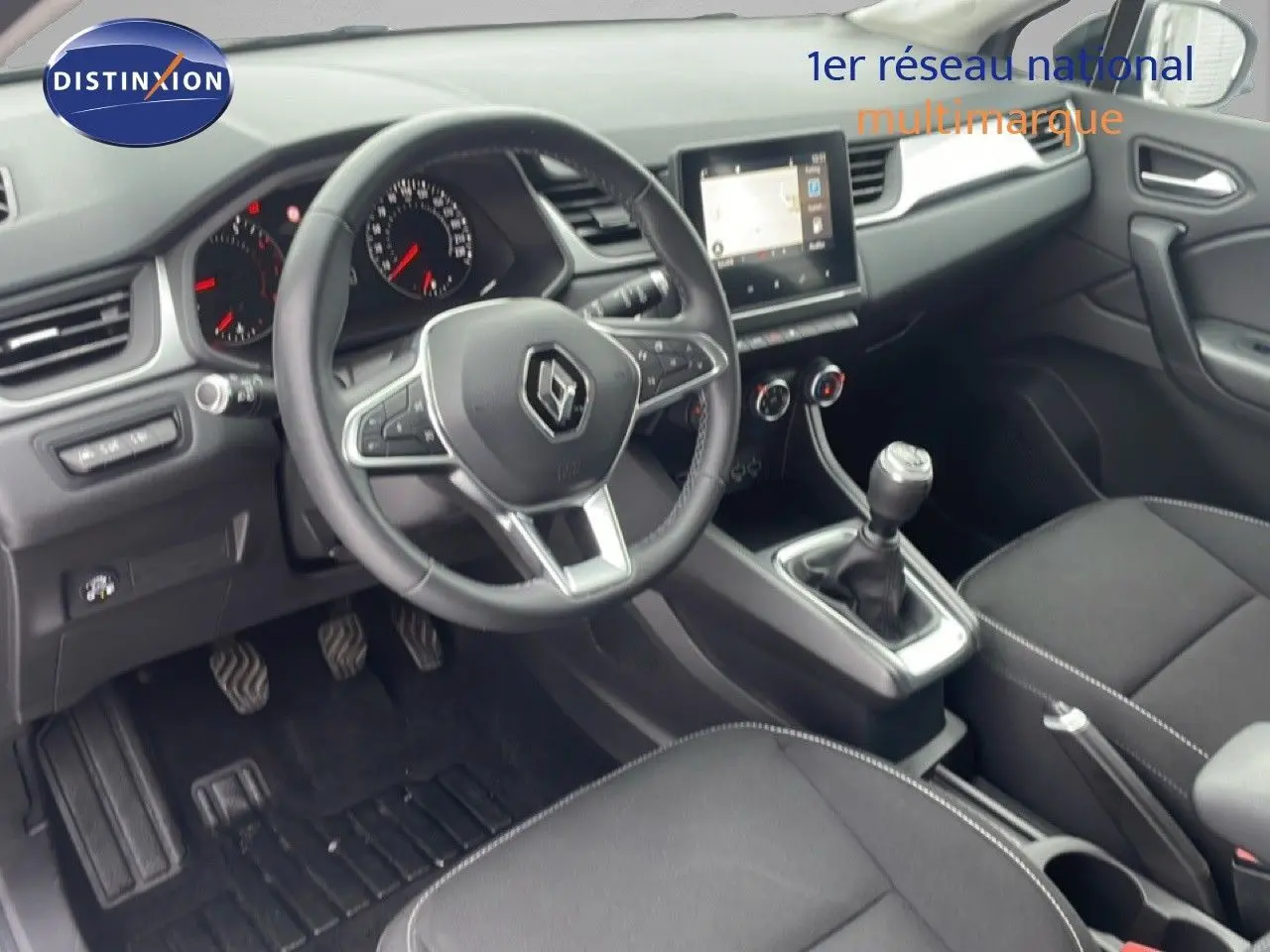 Vue intérieure côté conducteur du Renault Captur 2020, montrant le volant, la console centrale et la boîte manuelle.
