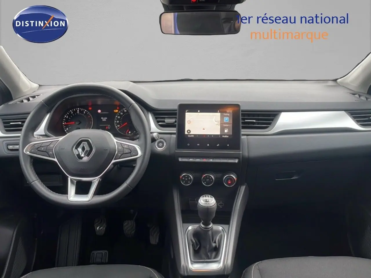 Vue intérieure frontale du tableau de bord du Renault Captur gris Cassiopée, avec volant multifonction et écran tactile central.