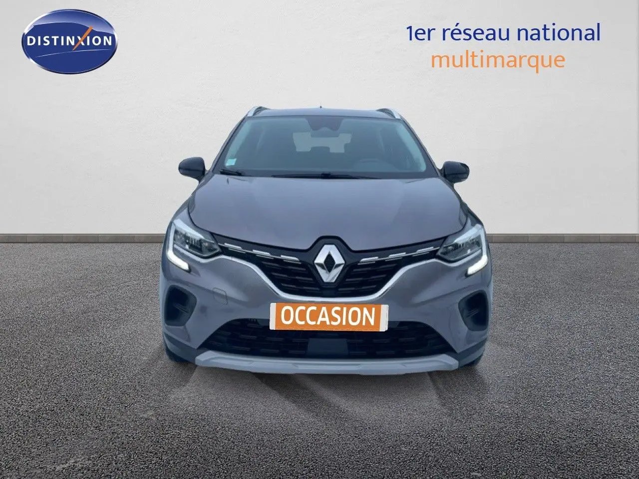 Vue frontale d'un Renault Captur gris cassiopée métal avec feux LED allumés et plaque "OCCASION" visible.
